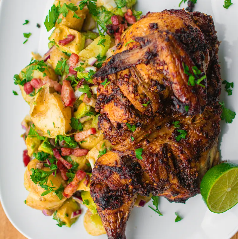 Half jerk chicken with potato salad and lime