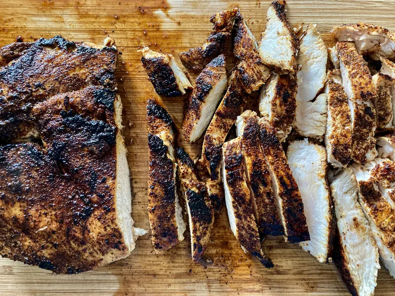 Sliced jerk chicken on a board